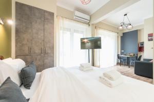 een slaapkamer met een wit bed en een tv aan de muur bij Let me Athens you! #3 in Athene
