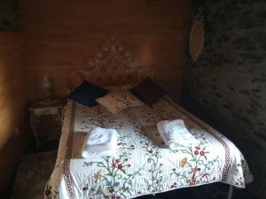 a bed with a white comforter and pillows on it at Casa da Vinha em Tabuaço - Douro in Tabuaço