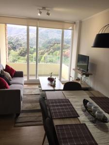 a living room with a couch and a large window at Papudo LPV in Papudo +26 photos