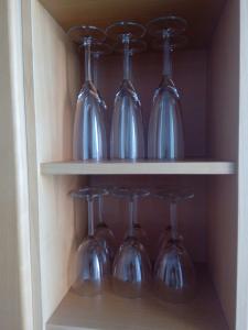 a cupboard with wine glasses and wine bottles at Apartment Widbominkulma in Pori