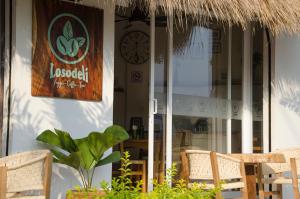 a clock on the side of a building with chairs at Casa Losodeli & Coworking- Adults Only in Puerto Escondido