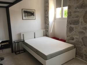 Ce lit se trouve dans une chambre dotée d'un mur en briques. dans l'établissement Amfora, à Opatija