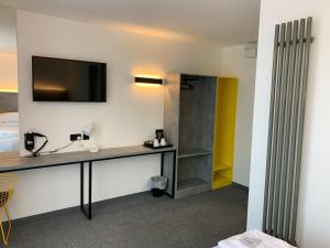 a room with a desk with a television and a bed at Motel Air Glasgow Airport in Paisley