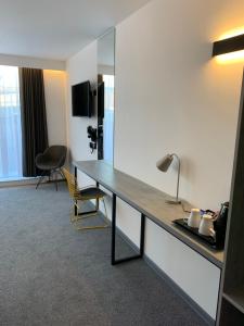 a room with a desk with a mirror and a chair at Motel Air Glasgow Airport in Paisley