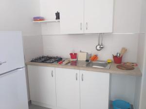 a kitchen with white cabinets and a sink at La Bussola in Porto Cesareo +16 photos