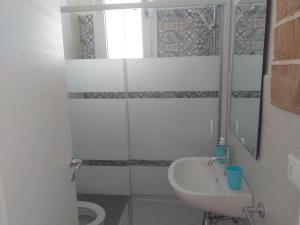a white bathroom with a sink and a toilet at La Bussola in Porto Cesareo