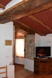 a living room with a window and a television at CASA RURAL XERT - CARMETA in Xert