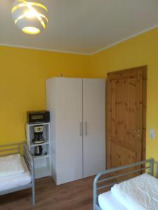 a bedroom with a white cabinet and a door at Pension Holmer Moorhof in Hartenholm