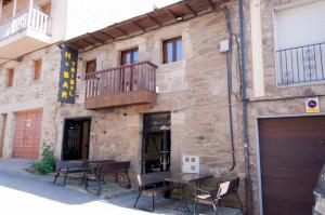 ein Gebäude mit einem Tisch und Stühlen davor in der Unterkunft Hostal Tribal in Puebla de Sanabria