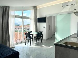 a kitchen and dining room with a table and chairs at The AP Fiumaretta in Ameglia