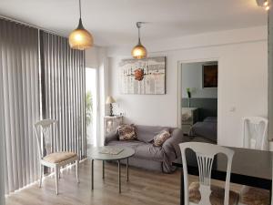 een woonkamer met een bank en een tafel en stoelen bij Lolita's house torre del oro in Sevilla