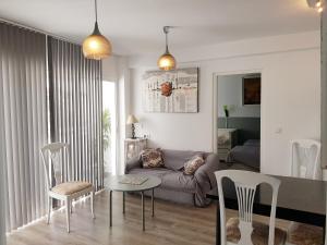 a living room with a couch and a table and chairs at Lolita's house torre del oro in Seville