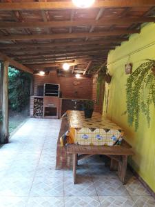 a patio with a wooden table and a kitchen at Sitio Recanto da Paz Chalés - casa e chalé para temporada in São Pedro da Serra