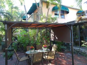 a patio with a table and chairs under a pergola at Suite Dreams Inn by the Beach in Key West
