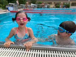 a boy and a girl in a swimming pool at Apartmani Neo in Sutomore