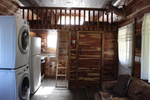 uma cozinha com máquina de lavar e secar roupa numa cabina em Amish made cedar cabin with a loft on a buffalo farm close to the Buffalo River em Marshall