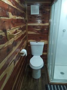 a bathroom with a toilet in a wooden wall at Amish made cedar cabin with a loft on a buffalo farm close to the Buffalo River in Marshall