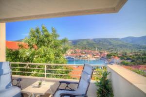 a balcony with two chairs and a view of the water at Apartments Villa Rojnica in Jelsa