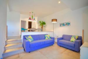 a living room with two blue couches and a table at Apartments Villa Rojnica in Jelsa