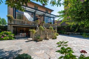 una casa con balcone e patio con piante in vaso di Villa Mery a Casale Monferrato