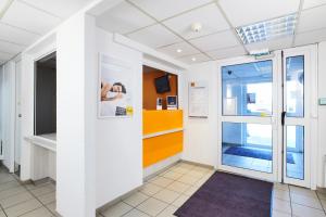 a hallway in a building with a door and a window at Premiere Classe Montreuil in Montreuil