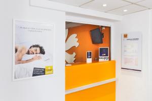 una porta arancione in una stanza con un poster appeso al muro di Premiere Classe Montreuil a Montreuil