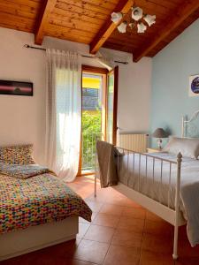 een slaapkamer met een bed en een glazen schuifdeur bij Villa Panoramica in Lavena Ponte Tresa