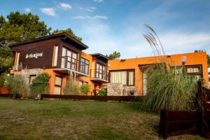 an orange house with a yard in front of it at Cabañas Marjumi in Mar de las Pampas