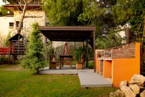 a pavilion in a garden with a bench and a table at Cabañas Marjumi in Mar de las Pampas