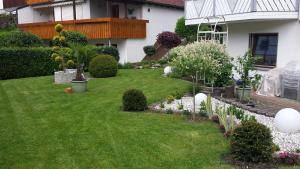 un jardín con flores blancas y plantas en un patio en Ferienwohnung Guth, en Wehr