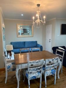a dining room with a table and a blue couch at Hostel Chaman in Osorno