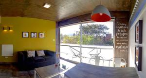 un soggiorno con divano, tavolo e ampia finestra di Depto 18 las Marías a San Salvador de Jujuy