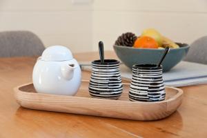 a wooden tray with stacks of plates and a bowl of fruit at Loft Over The Vines in Richmond
