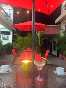 a red umbrella sitting on top of a table at Hotel El Reformador in Puerto Barrios +32 photos