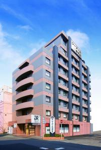 ein großes Apartmenthaus mit einem Schild drauf in der Unterkunft GR Hotel Suidocho in Kumamoto