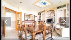 Un comedor con mesa y sillas de madera. en Casa La Guitarra, en Nerja