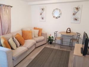 a living room with a couch and a table at Vetrelax Harwich Deluxe Suite in Harwich