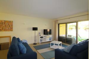 a living room with a blue couch and a tv at Tavira Dream Holidays in Tavira