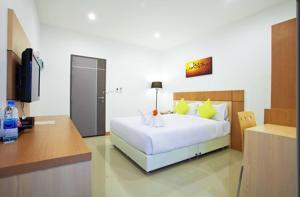 1 dormitorio con 1 cama blanca grande y escritorio en La Belle, en Chiang Rai