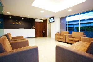 a waiting room with couches and a flat screen tv at La Belle in Chiang Rai