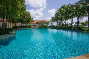 uma grande piscina azul com árvores ao fundo em Profolio @ Straits Quay em George Town