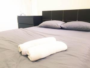 a bed with two white towels on top of it at Taiping Centre Point Suite 7 by BWC in Taiping