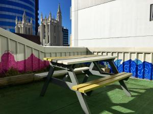 a picnic table and a bench on a rooftop at Trek Global Backpackers in Wellington