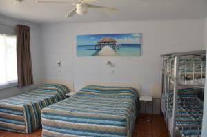 um quarto com 3 beliches e uma ventoinha de tecto em Sunburst Motel em Gold Coast
