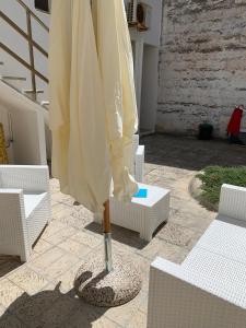 um guarda-chuva branco sentado em cima de um pátio em Villa Azzurra Sct em Santa Cesarea Terme