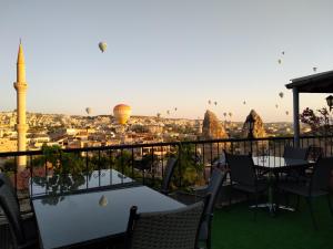 a view of the city from a hotel balcony with hot air balloons at Arch Palace in Göreme