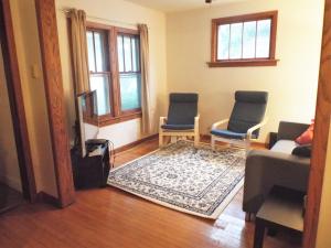 a living room with two chairs and a rug at Comfortable 3 BR Craftsman Bungalow in Milwaukee's Bay View Neighborhood in Milwaukee