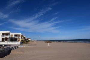 a beach with houses and an umbrella and the ocean at Sector 5 Napols AP844 in Oliva