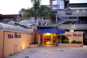 a hotel with a tree in front of a building at Tea Palace Hotel in Casapulla