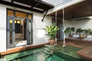 a house with a swimming pool and a patio at Anantara Lawana Koh Samui Resort in Chaweng